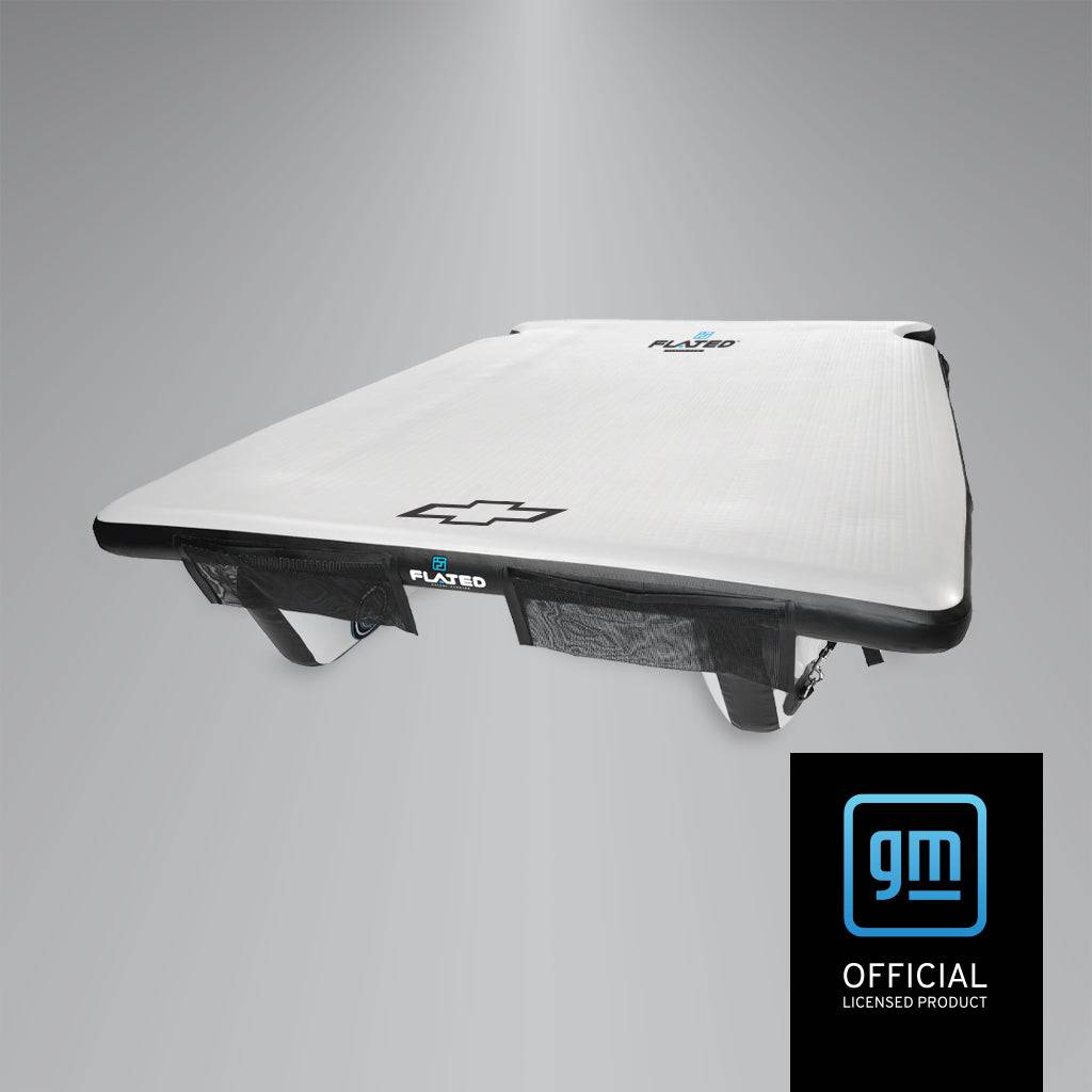 The MID-SHORT COLORADO DECK50 by FLATED is a rectangular white floating truck bed platform with black trim, Chevrolet logo, and a GM Official Licensed Product logo in the lower right corner.
