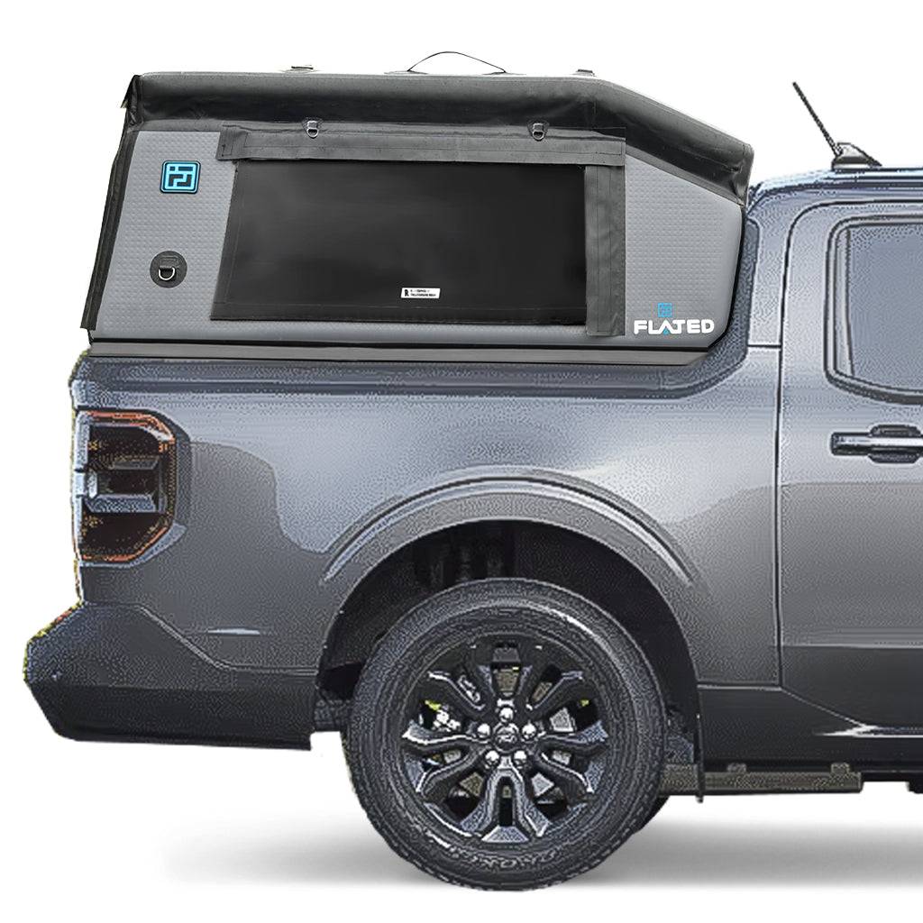 A grey pickup with a raised, inflatable FLATED COMPACT-MAVERICK MR46 truck shell on the bed, featuring a large side window and logo. This camper shell adds height and storage, making it a versatile topper.
