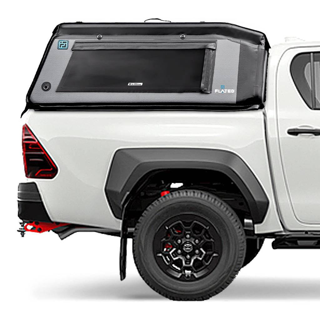 A white pickup truck is fitted with a FLATED MID-SHORT MR411 black and gray Air-Topper inflatable shell, including a side window and secure fastenings, plus sleek black wheels and red accents under the rear bumper.