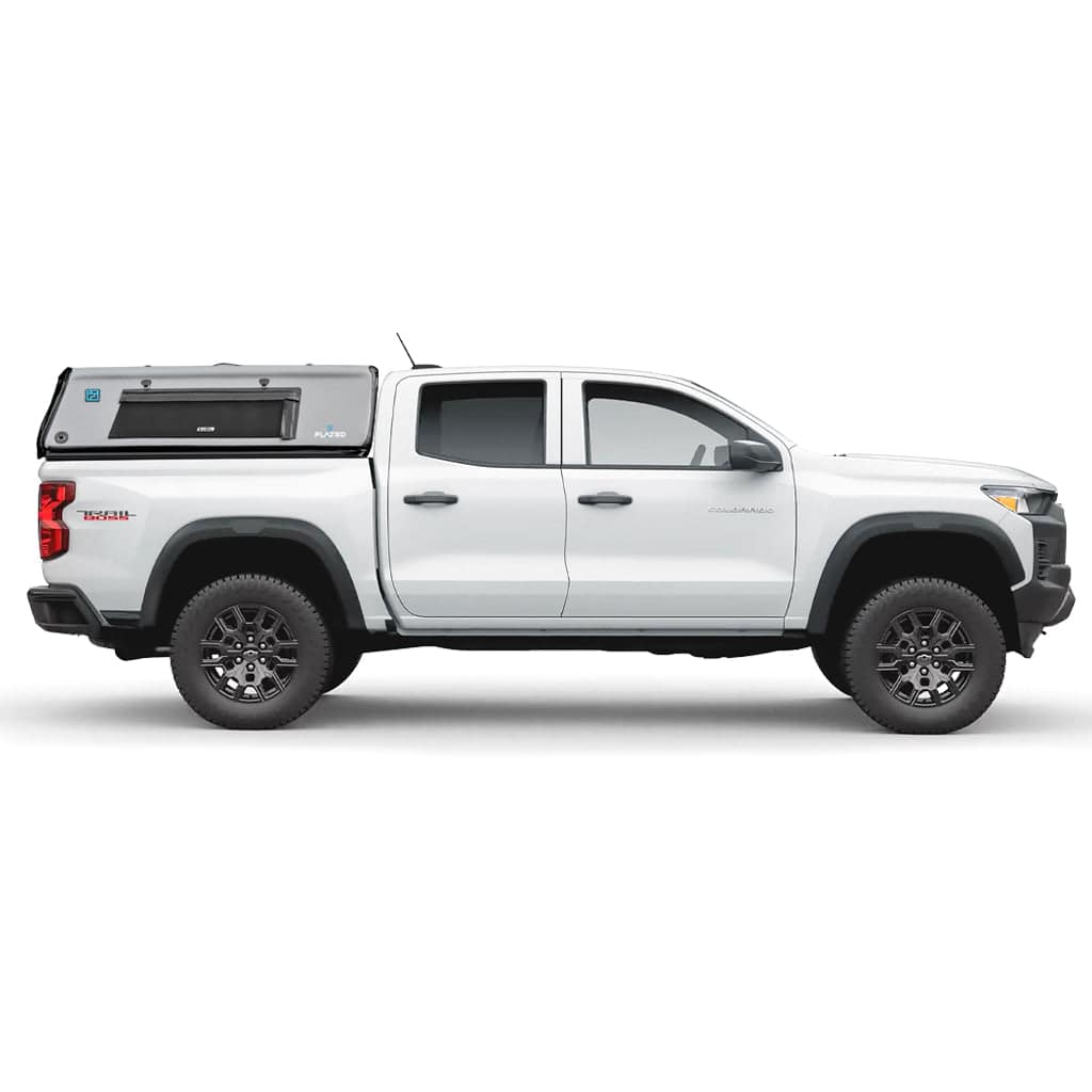 A blue Toyota Tacoma pickup truck with a gray FLATED MID-SHORT CAP50 inflatable truck shell attached to the open cargo area, shown from the side.