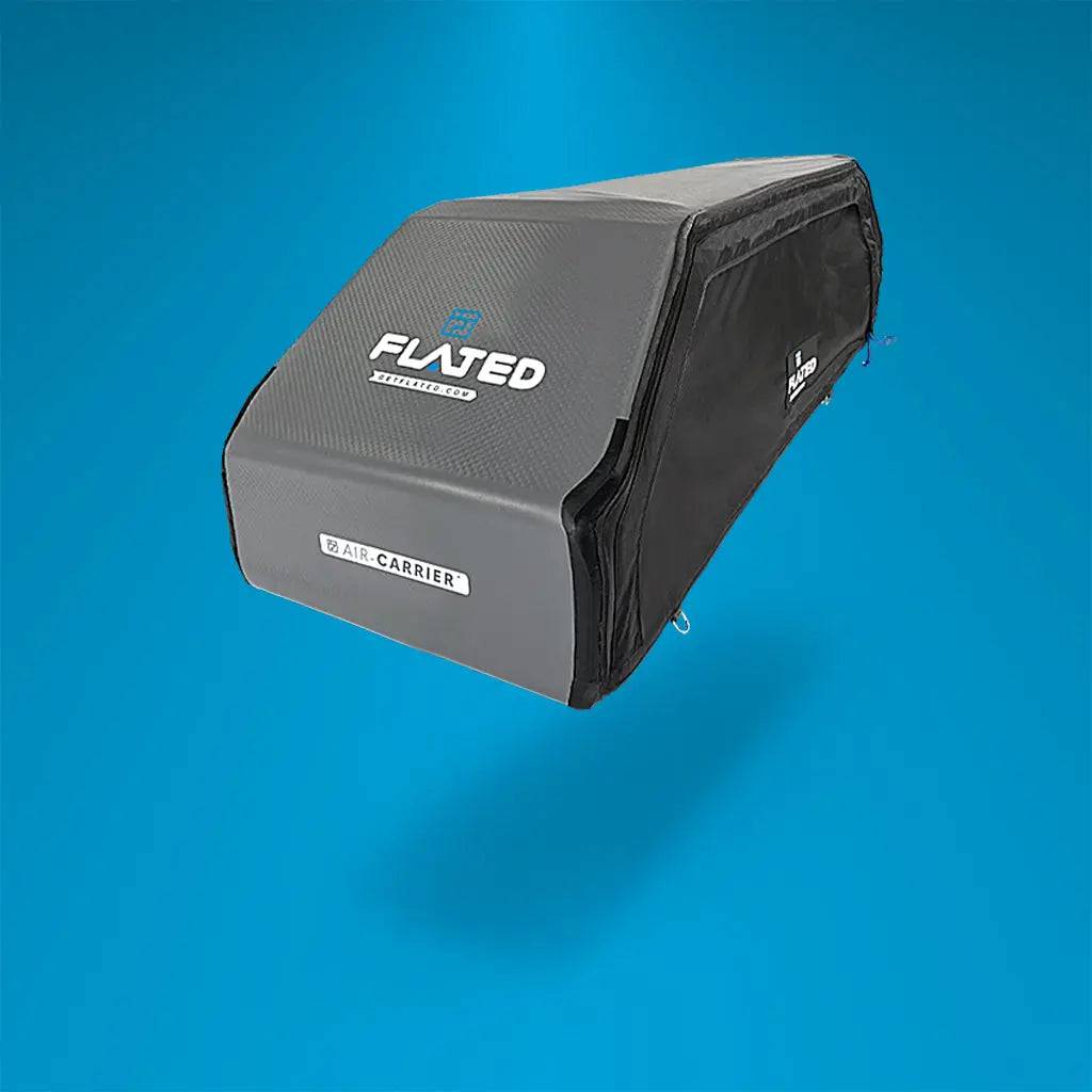 The FLATED SPORT CARRIER15 (OPEN BOX) is a rectangular, soft-sided rooftop cargo carrier in gray and black with a zippered closure and reinforced edges, ideal for secure gear storage during travel. Shown against a blue gradient background.