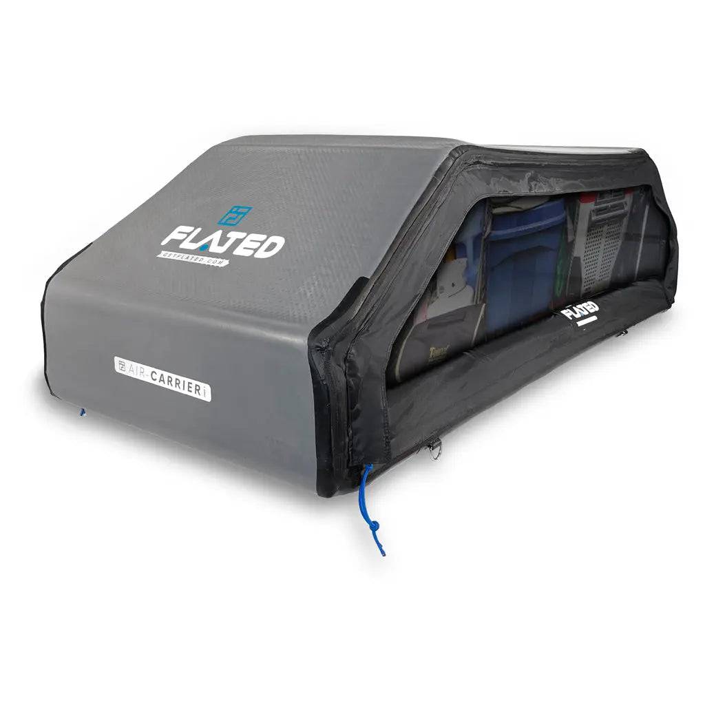 The FLATED SPORT CARRIER15 (OPEN BOX) is a gray inflatable truck bed cover with a clear side showing neatly stored gear in bins and bags. Its rectangular shape secures with blue corner straps, making it perfect for travel adventures.