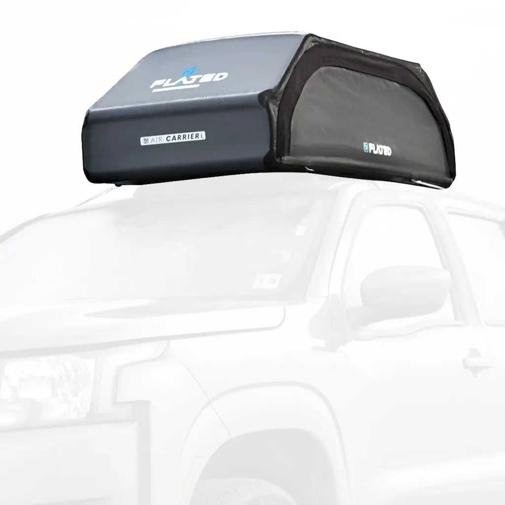 A FLATED MEDIUM CARRIER15 rooftop cargo box in black and gray is mounted on a white SUV, with the partially visible vehicle shown against a white background.