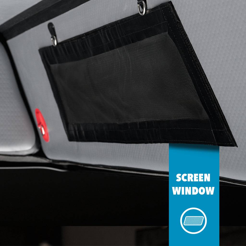 Close-up of a black mesh screen window (FLATED FULL-STANDARD DT CAP64) for a full-size truck bed attached to a gray surface with two hooks; a blue label at the bottom right reads SCREEN WINDOW with a window icon.