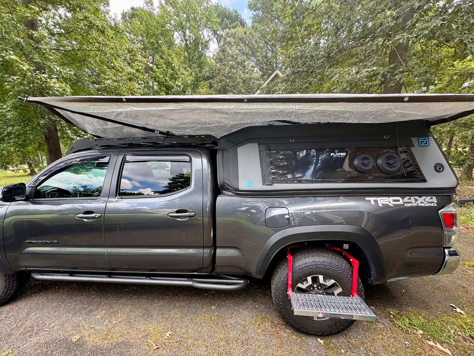 Gen 3 Tacoma with FLATED MR60 Topper at a campsite. Truck has awnings and A/C unit.