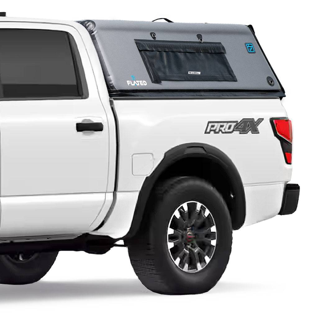 A white pickup with a gray FLATED FULL-SHORT CAP54 (OPEN BOX) inflatable topper, featuring black trim and window, snugly covers the truck’s full-size short bed. Also branded by Leer.