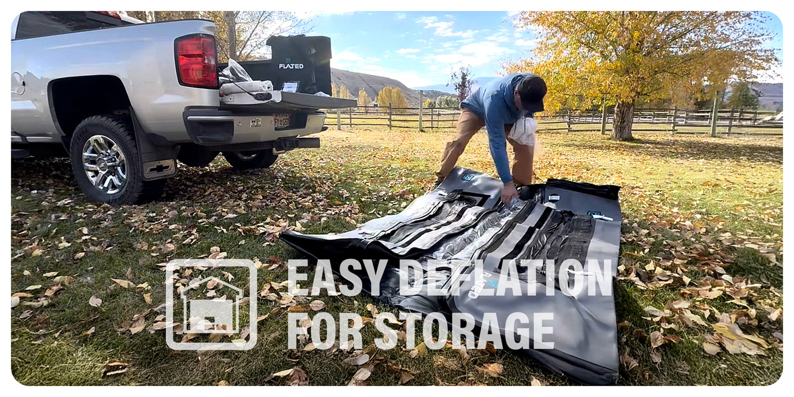 A person deflates a large black inflatable mattress on the ground next to a pickup truck in a grassy, tree-filled park. Text overlay reads: Easy deflation for storage with an icon of a box.