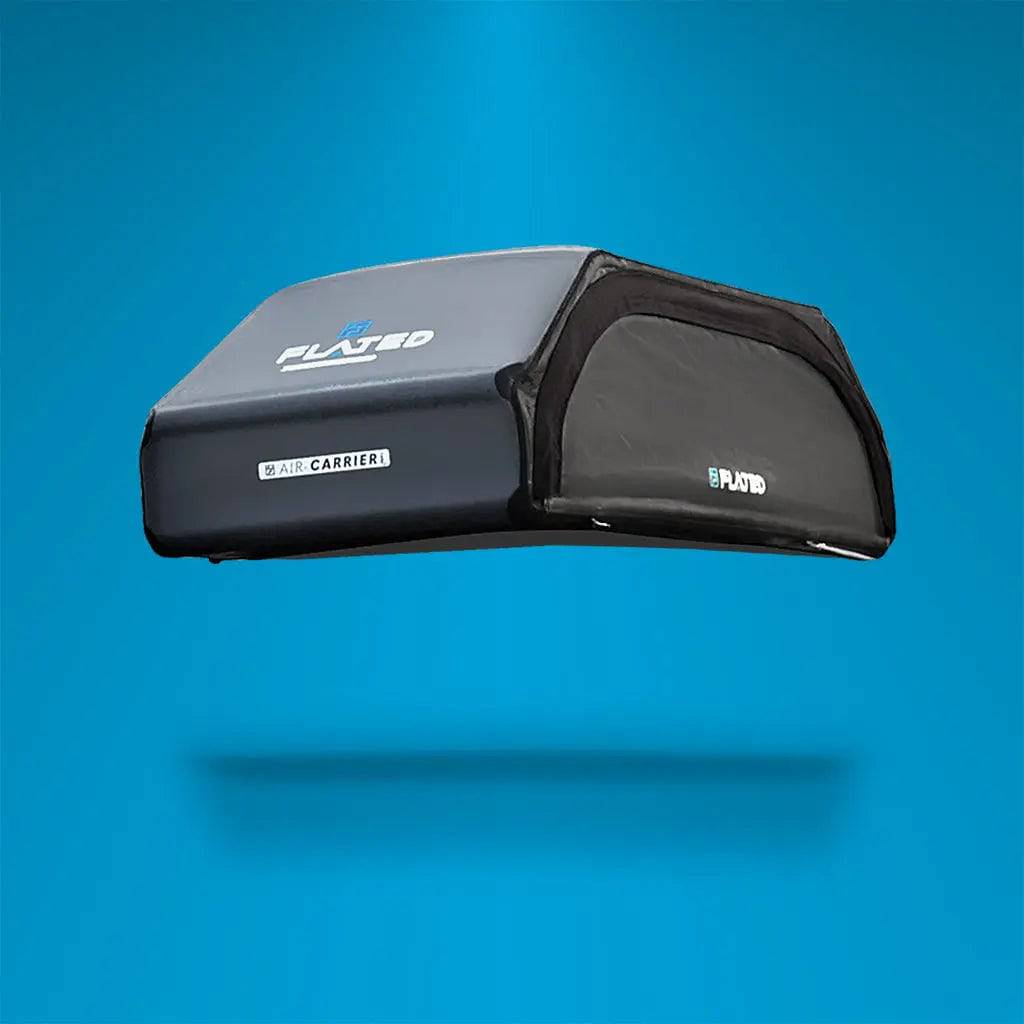 A FLATED LARGE CARRIER23 (OPEN BOX) in black and gray is mounted on top of a white SUV, shown from the side against a plain white background, making it the ideal rooftop cargo carrier for travel and gear storage.