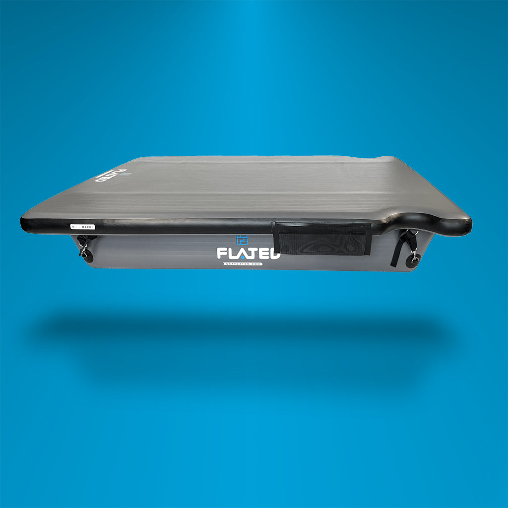 Rectangular inflatable raft with black edges and a flat gray surface, labeled FLATEL on the side, floating against a blue gradient background.