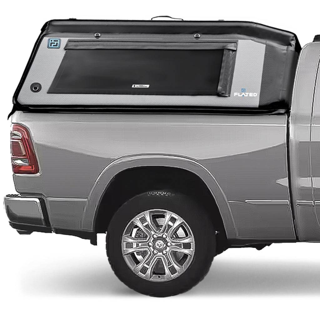 A gray pickup truck with a FLATED FULL-STANDARD DT MR64 black and gray inflatable truck shell attached, featuring a large side window and the FLATED logo.