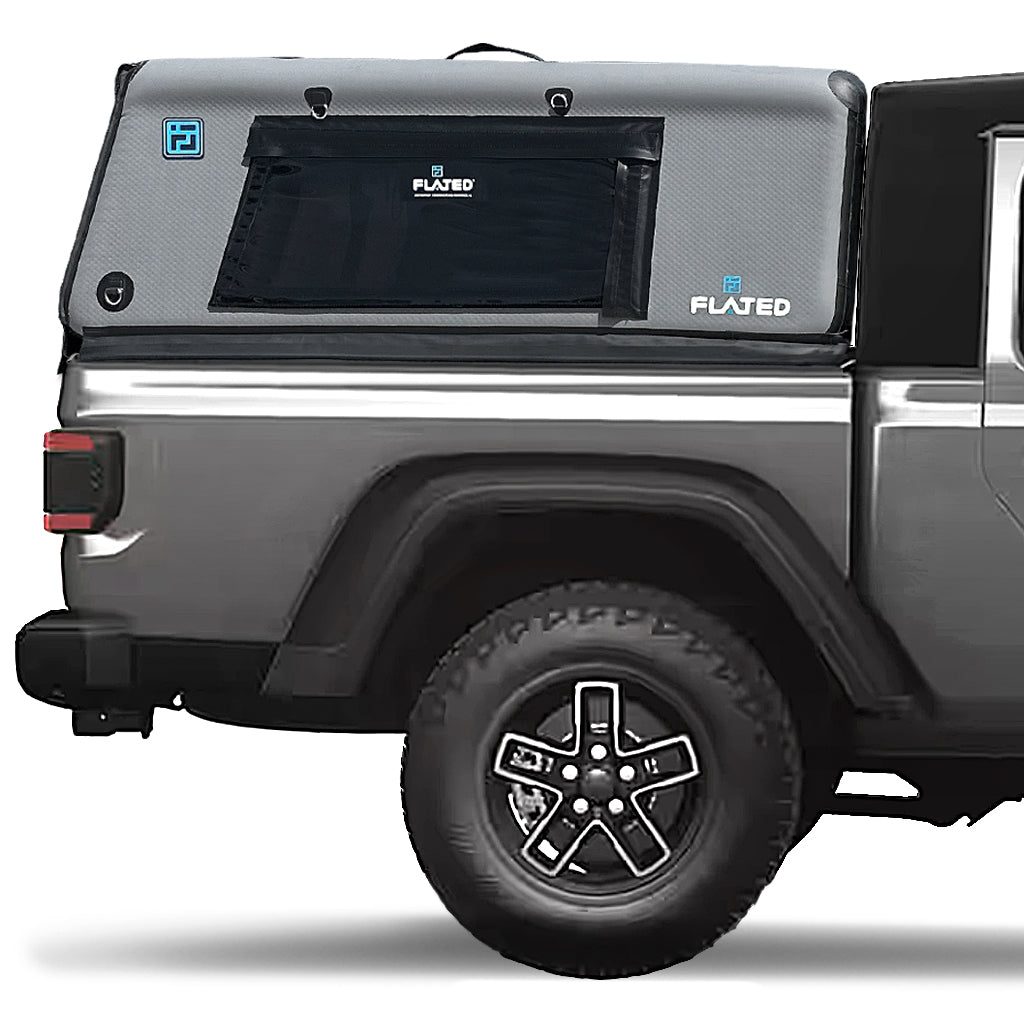 A gray pickup truck is equipped with a FLATED MID-SHORT CAP51 black and gray Air-Topper inflatable truck shell, securely installed over the bed with a side window for convenient coverage during outdoor adventures.