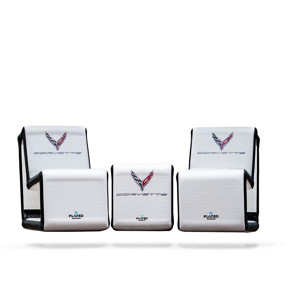 Four FLATED COMPACT-SIZE CORVETTE SET inflatable white seats with black trim, Corvette logo, and CORVETTE text are arranged in pairs on a white background—ideal for frunk-gating or portable event seating.
