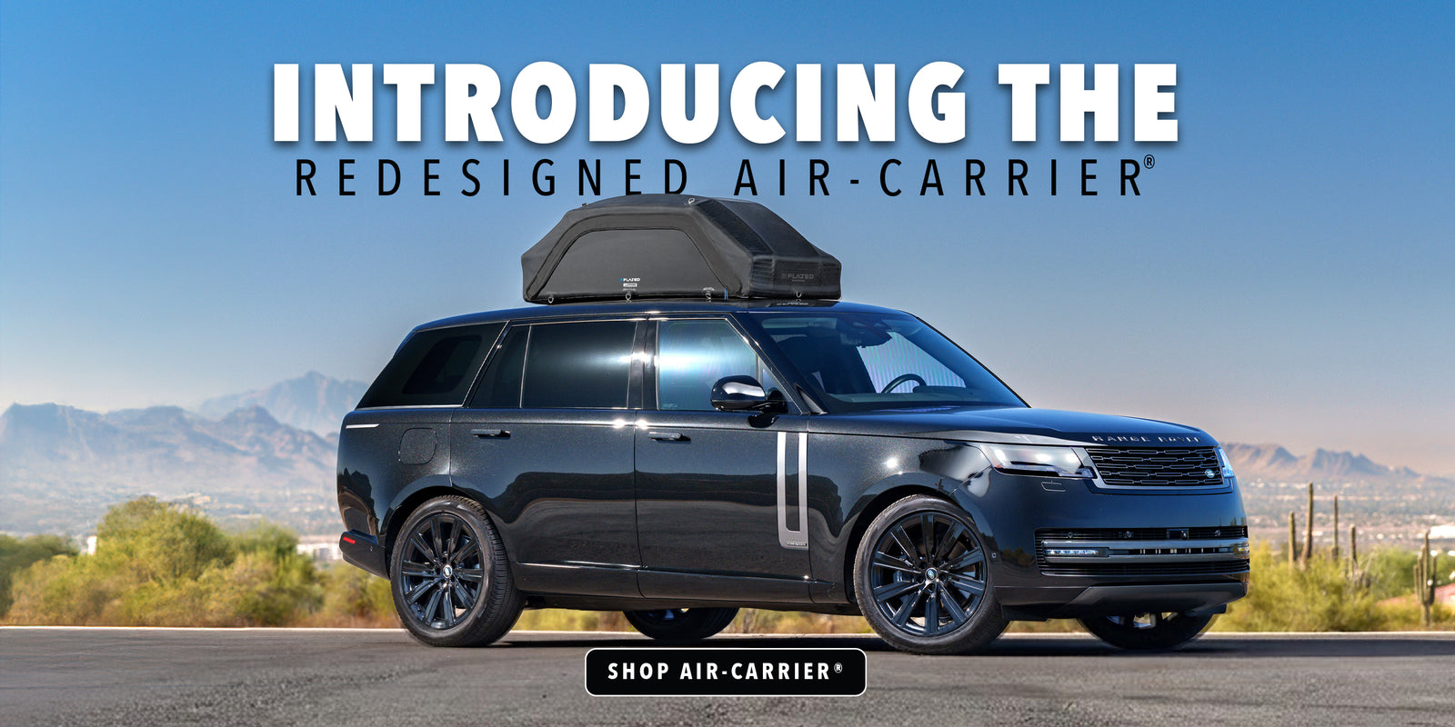 Black Range Rover with a roof-mounted cargo carrier parked in a desert landscape; overlay text reads Introducing the redesigned Air-Carrier and Shop Air-Carrier.