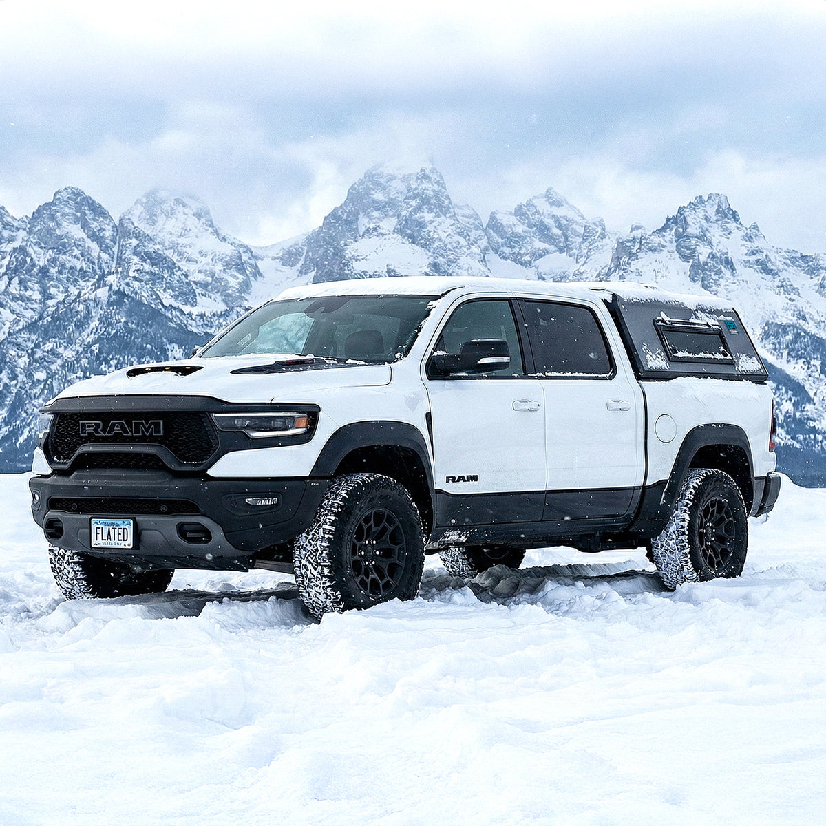 White Ram truck in a snowy landscape with mountains in the background. (Mopar Affiliate)