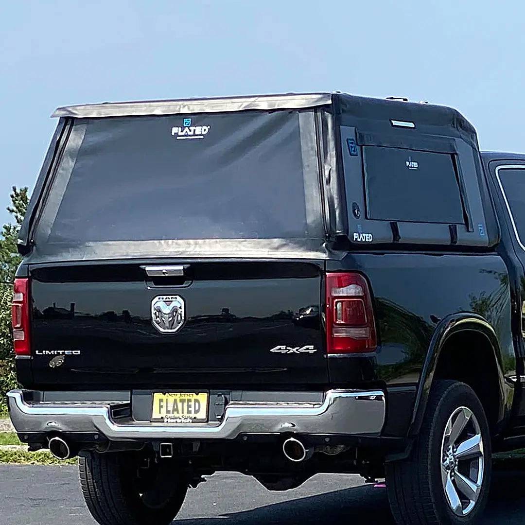A FLATED FULL-SHORT MR56 (OPEN BOX) inflatable truck shell is mounted on a white pickup, with large side windows and a snug fit for secure, covered storage.