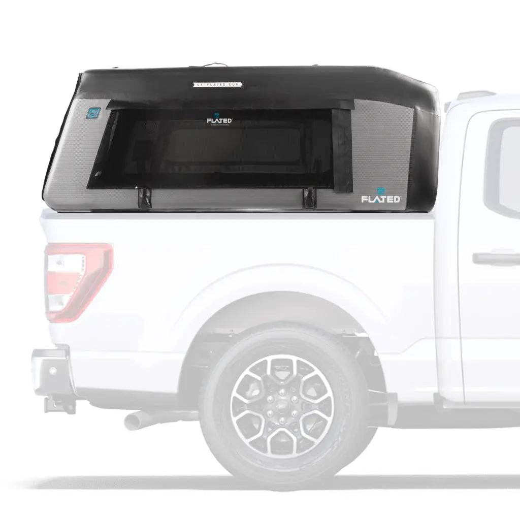 A FLATED FULL-SHORT MR56 (OPEN BOX) inflatable truck shell is mounted on a white pickup, with large side windows and a snug fit for secure, covered storage.