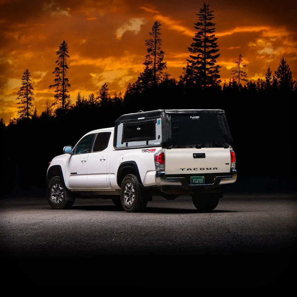A white pickup truck with a black and gray FLATED MID-LONG MR60 (OPEN BOX) Air-Topper inflatable truck bed topper installed, shown in profile on a plain white background.
