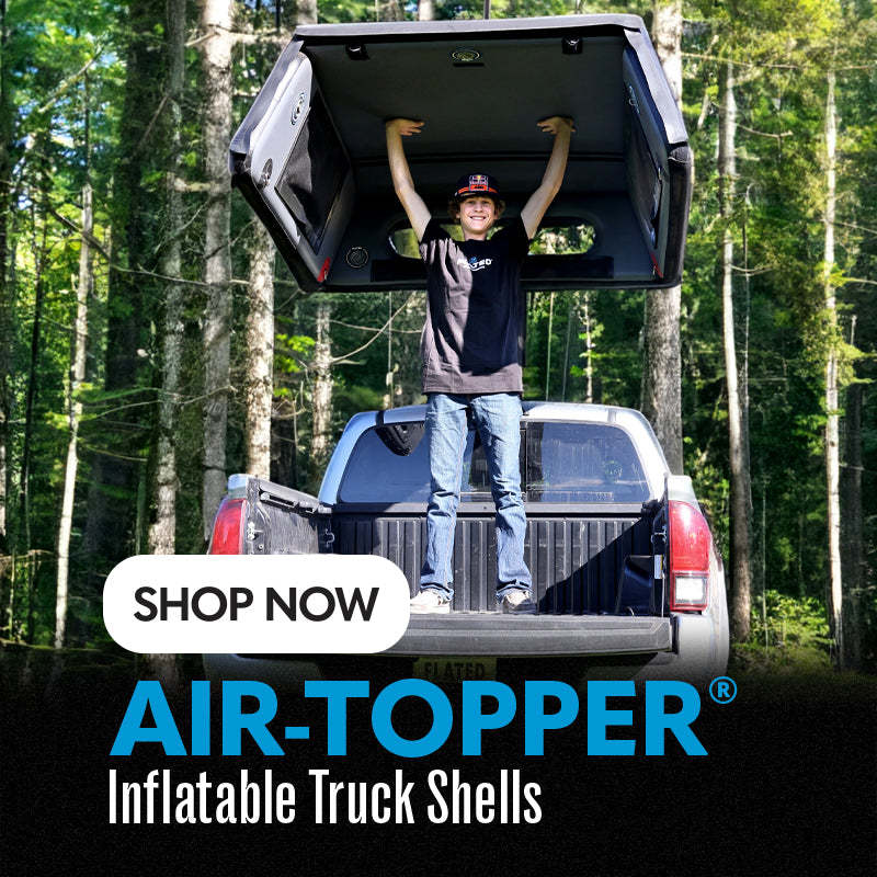 A person stands in the bed of a white pickup truck holding up an inflated truck shell, surrounded by trees. Text reads: SHOP NOW. AIR-TOPPER® Inflatable Truck Shells.