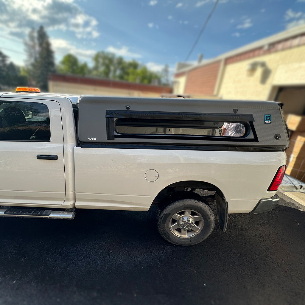 White truck with a FLATED air-topper 8' cap. 