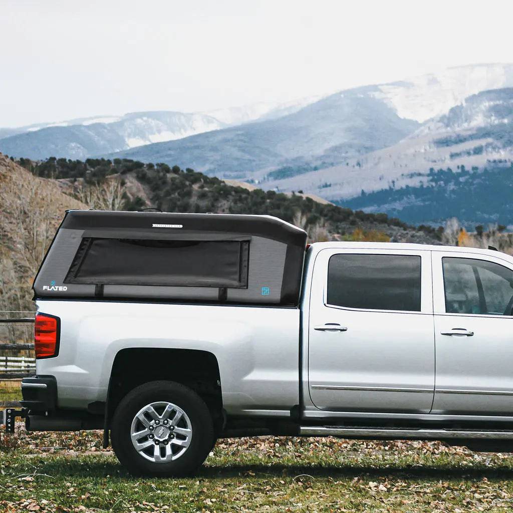 A white pickup truck with a black and gray FLATED FULL-STANDARD MR66 (OPEN BOX) Air-Topper inflatable shell mounted on the bed, shown in profile view against a white background.